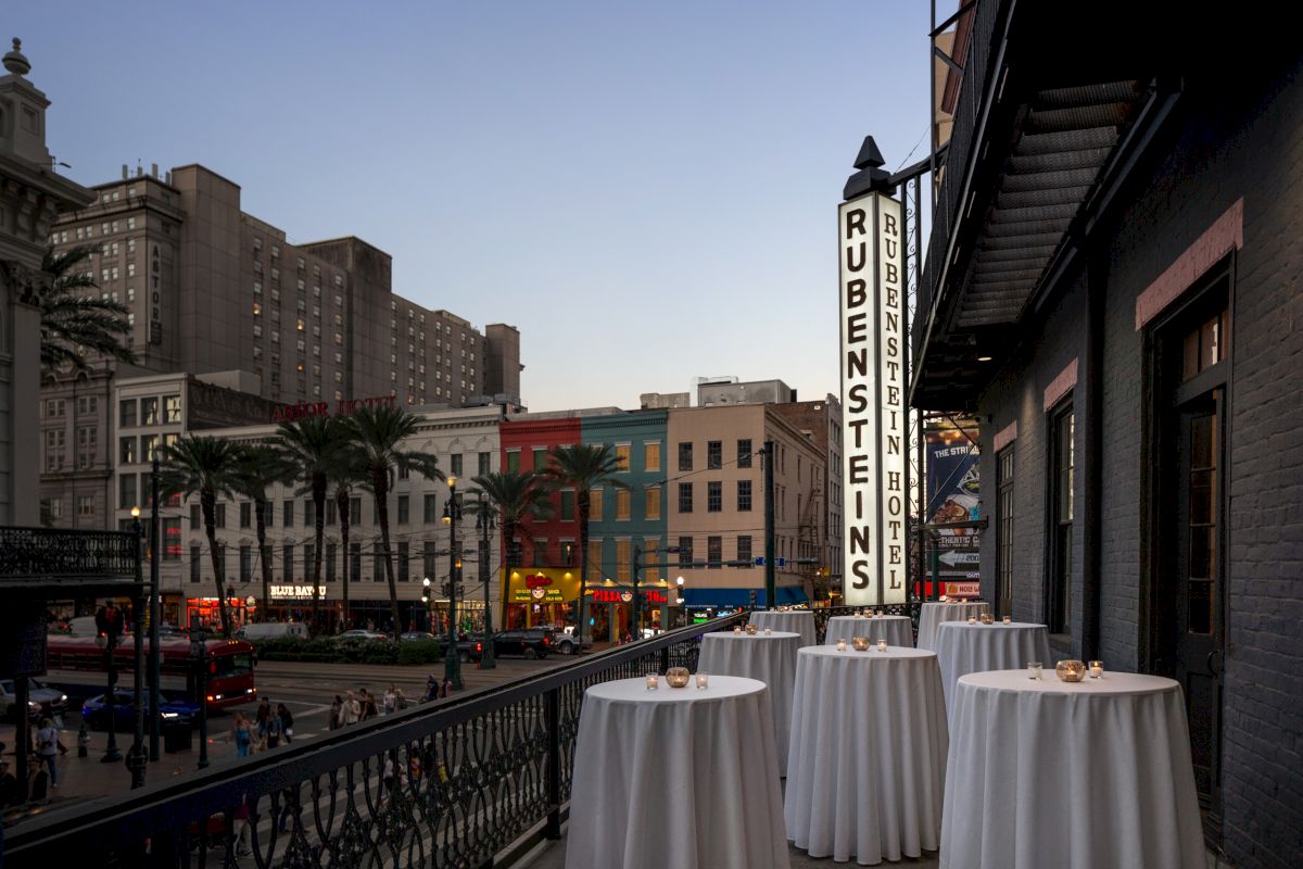 A balcony with white tables and a city view