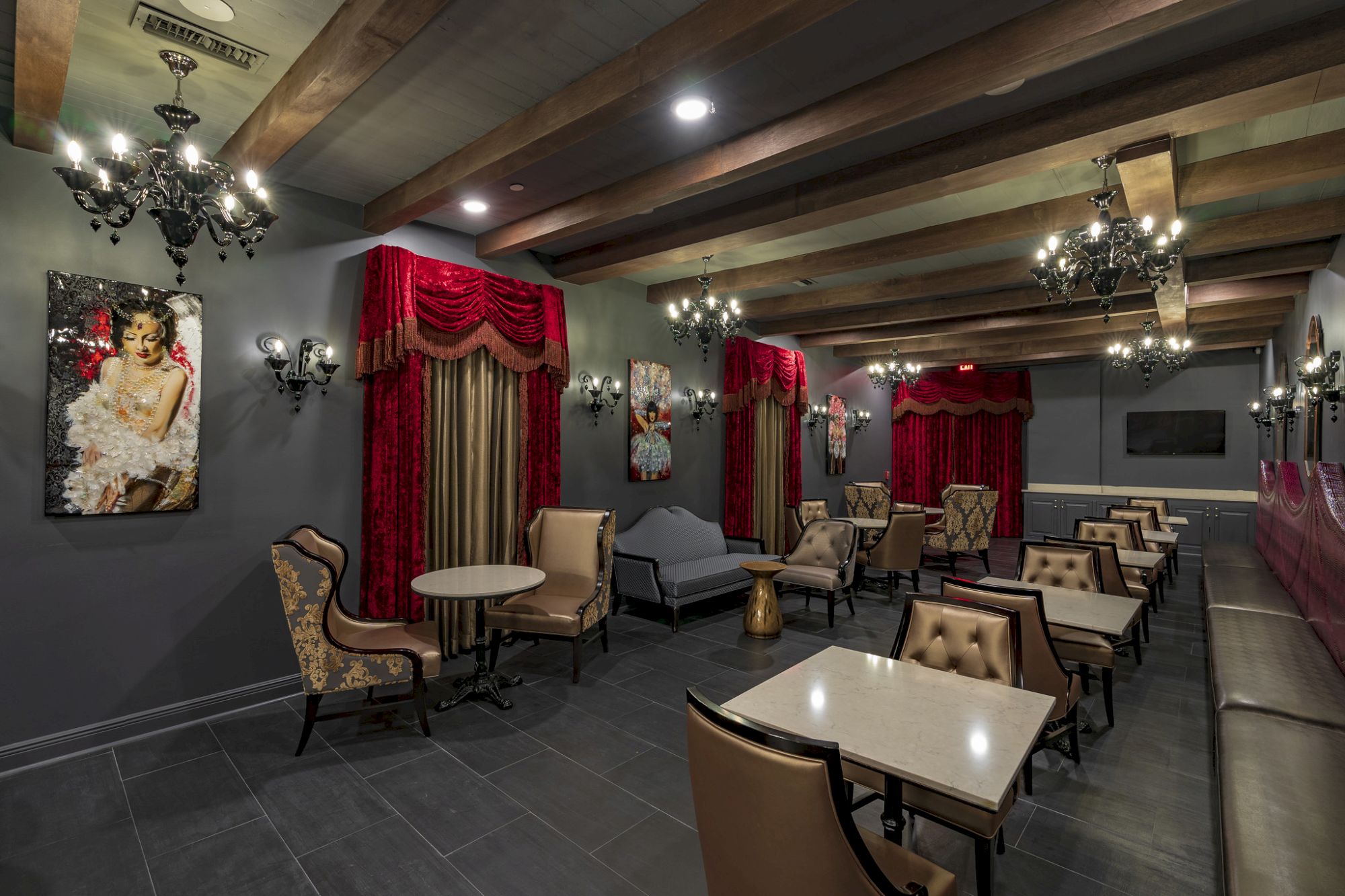 A luxurious lounge with tables, chairs, and chandeliers.